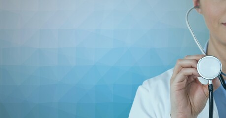 Mid section of female doctor holding stethoscope against textured gradient blue background