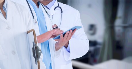 Mid section of team of doctors against hospital in background