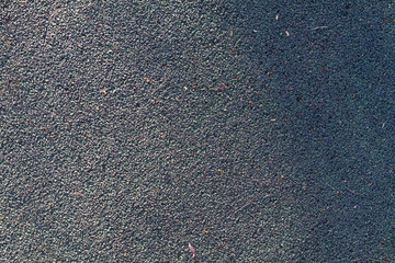 Old rubber surface on the sports field made of fine rubber crumbs of green color