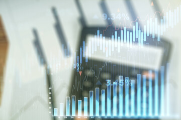 Abstract virtual financial graph hologram on blurry calculator and papers background, financial and trading concept. Multiexposure