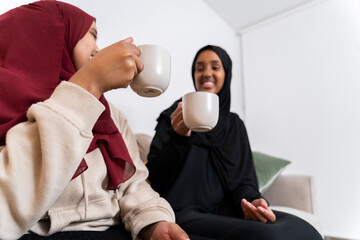 Two Black Muslim women having cake and dessert at home