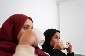 Two Black Muslim women having cake and dessert at home