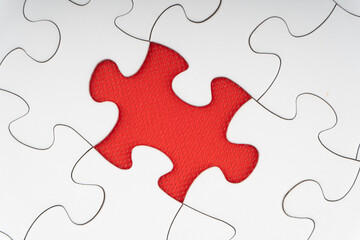 Fototapeta premium Red jigsaw puzzle pieces on red background. Copy space and business concept