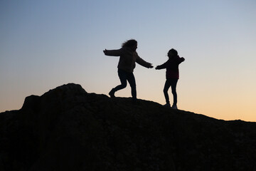 silhouettes of people in the mountain with sunrise sky background