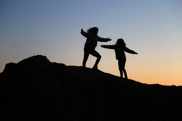 silhouettes of people in the mountain with sunrise sky background