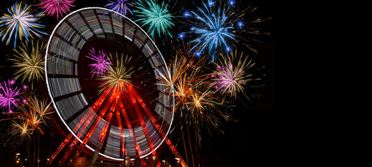 Summer festival party background banner panorama - ferris wheel in motion and colorful fireworks at...