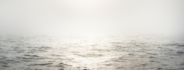 Baltic sea in a morning fog at sunrise, Sweden. View from a sailing boat. Soft golden sunlight,...