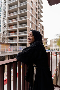 Black Muslim teenage girl standing on a balcony