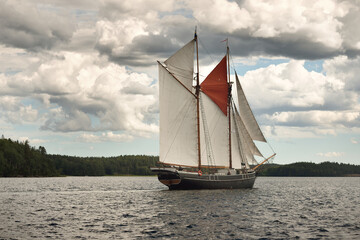 An elegant two-masted gaff schooner (training tall ship) sailing in Mälaren lake, Sweden. Travel, history, traditions, transportation, sailing, sport, cruise, regatta, teamwork. Panoramic view