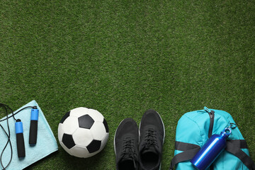 Obraz premium Flat lay composition with sports equipment on green grass, space for text
