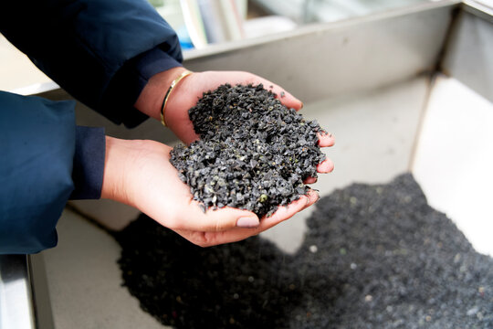 close up of waste plastic granulate in a hand
