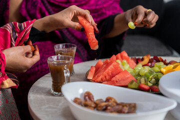 Black Muslim women eating fruit from fruit platter