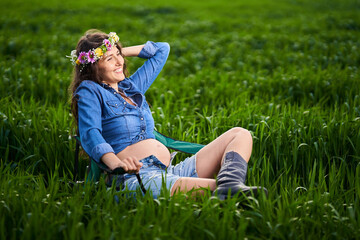 Fototapeta premium Pregnant woman in a wheat field
