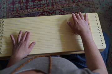 Woman holding a monochord, sound healing instrument in a therapy session.