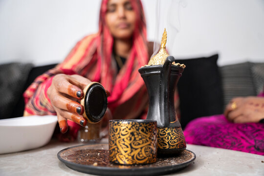 Black Muslim woman putting on incense 