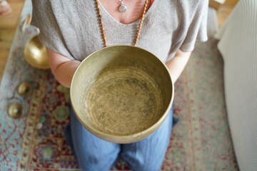 Caucasian woman holding a Tibetan singing bowl in her hand for sound healing therapy 