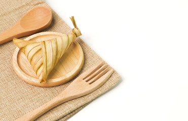 Ketupat palas or rice dumpling on wooden plate. Ketupat palas is a natural rice casing made from young coconut leaves or cooking rice during Eid Mubarak or Eid Fitri.