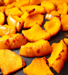 Pieces of pumpkin baked on a baking sheet. Food