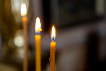 A wax candle burns in an Orthodox church.
