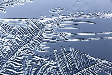 Blue patterns from frost on glass as a background.