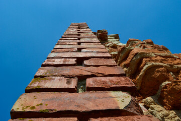 Close-up of a red brick masonry wall. View up the blue sky.