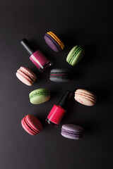 Different colored macarons and nail polishes