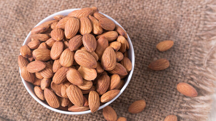 Almond nuts in a white bowl wooden background, selective focus.front view.close-up.