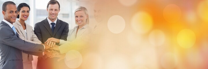 Composition of smiling business people stacking hands with spots of light