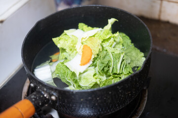 Lettuce and carrot boil in pot