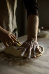 Male hands kneading dough on the table