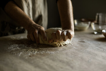 Male hands kneading dough on the table