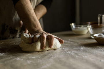 Male hands kneading dough on the table