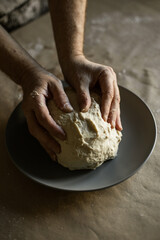 Male hands kneading dough on the table