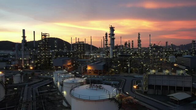 Aerial view of Chemical oil refinery plant, power plant and metal pipe on sunset sky background.