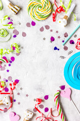 Colored party sweets and confetti on stone background top view mockup