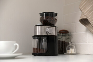Modern coffee grinder on counter in kitchen