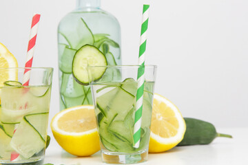 Lemon cucumber water with colorful paper straw. Healthy detox drink. 