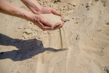 Man holding sand in his hands selective focus