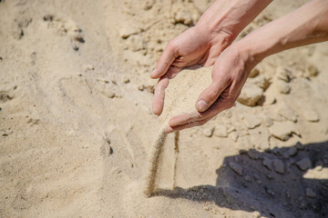Man holding sand in his hands selective focus