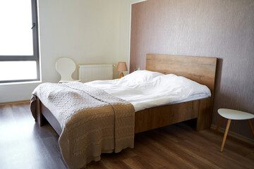 Fototapeta na wymiar Modern stylish and cozy interior of a bedroom with a double bed in the apartment