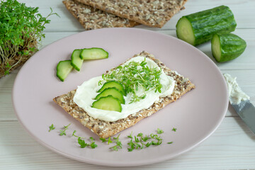 healthy crisp bread with cream cheese and cress on a plate