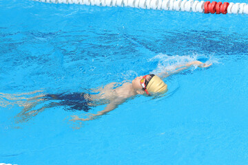 Boy practicing swimming with a board grip pose