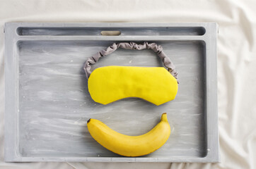 Good sleep foods - banana, milk  and sleep mask. Insomnia treatment. Healthy night sleep. Yellow...