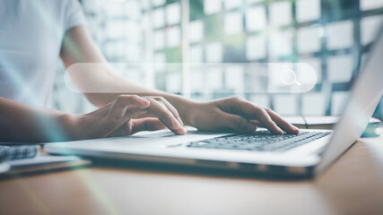 Searching and big data concepts with female hand using computer laptop in office with search engine...