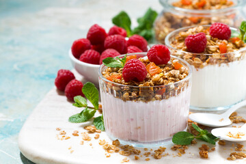 sweet dessert with granola, fresh raspberries and fruit yoghurt on board