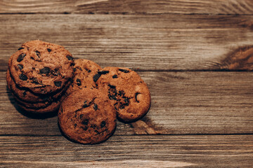 Chocolate aromatic cookies with pieces of cocoa top view on a background of wooden boards.