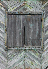 wooden texture background of the herringbone board. carved wooden architraves window boarded up uninhabited. green grey silver color - obrazy, fototapety, plakaty
