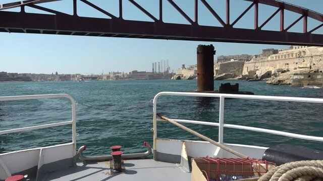 Sailing in Malta waters and passing under metal bridge.