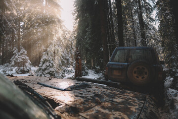 Offroad car trip through the Ukrainian Carpathians in winter. View from the window, Christmas tree and snowy road. External expedition. Nice sun
