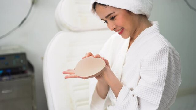 Young woman patient preparing for breast augmentation with silicone breast augmentation is testing silicone breast augmentation in a beauty clinic.